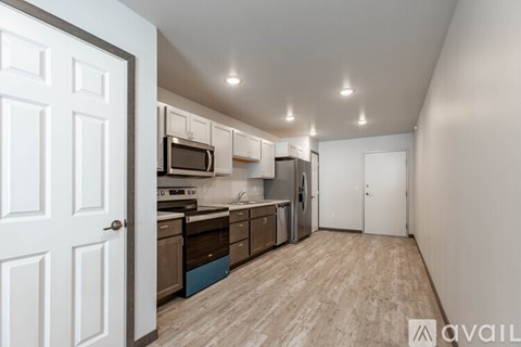 A kitchen with a white door and a white wall.
