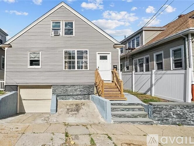 A house with a grey siding and a white door is for sale.