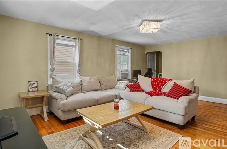 A living room with a grey couch and a wooden coffee table.