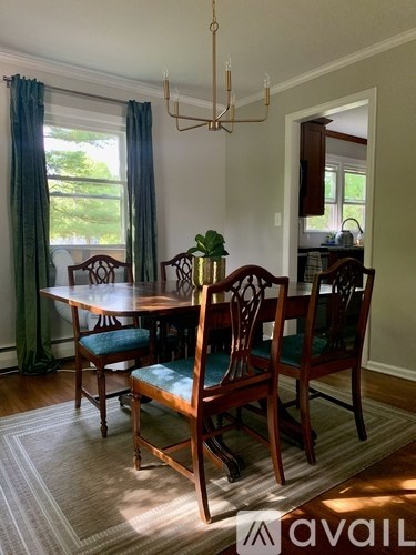 A dining room with a table and chairs.
