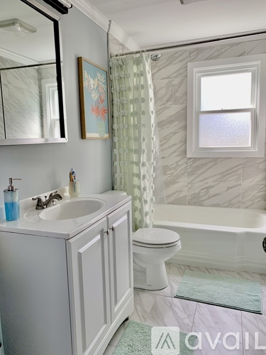 A bathroom with a white toilet, sink, and bathtub.