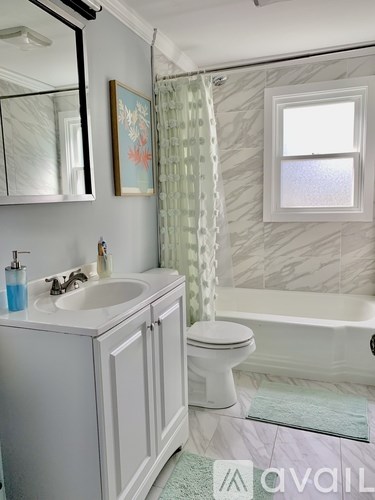A bathroom with a white toilet, sink, and bathtub.