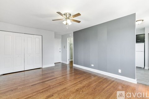 A spacious room with a ceiling fan and wooden flooring.