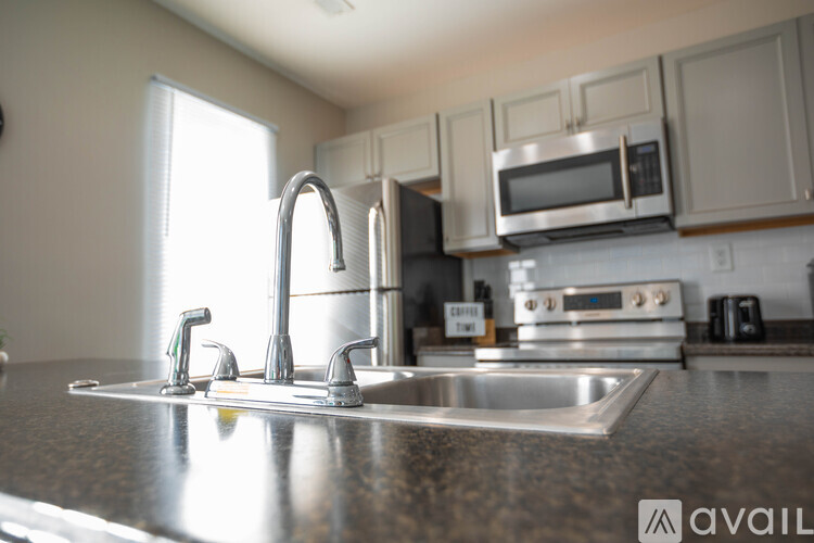 A kitchen with a stainless steel sink and faucet.