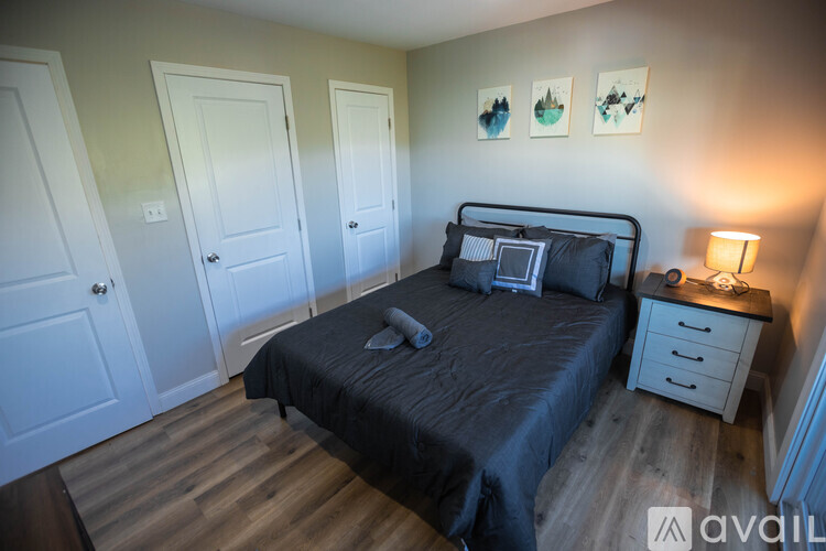 A bedroom with a bed, nightstand, and two doors.