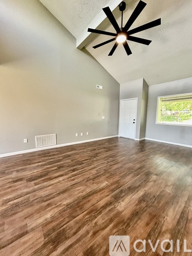A room with wooden flooring and a ceiling fan.