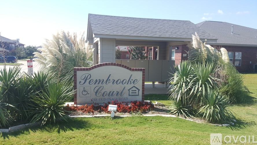 A sign for Pembrooke Court is in front of a building.