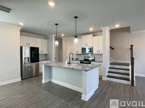 A modern kitchen with a refrigerator, microwave, and stove top oven.