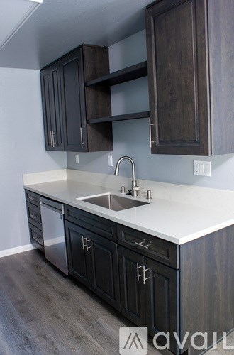 A kitchen with dark wood cabinets and a white countertop.