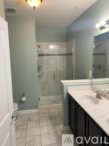 A bathroom with a glass shower door and a sink.