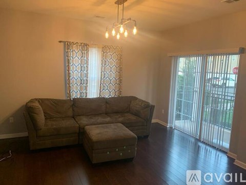 A living room with a couch and ottoman.