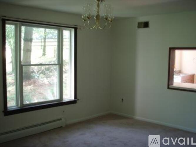 A room with a window and a chandelier.