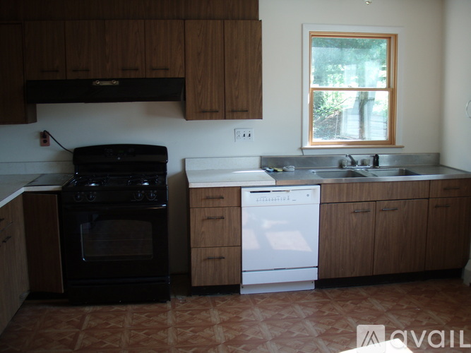 A kitchen with a black oven and white dishwasher.