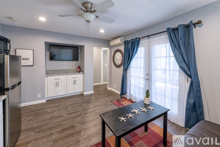 A kitchen with a refrigerator, a dining table, and a ceiling fan.