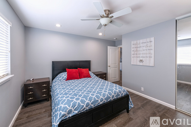 A bedroom with a bed, dresser, and ceiling fan.
