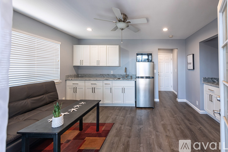 A kitchen with white cabinets and a black table with a plant on it.