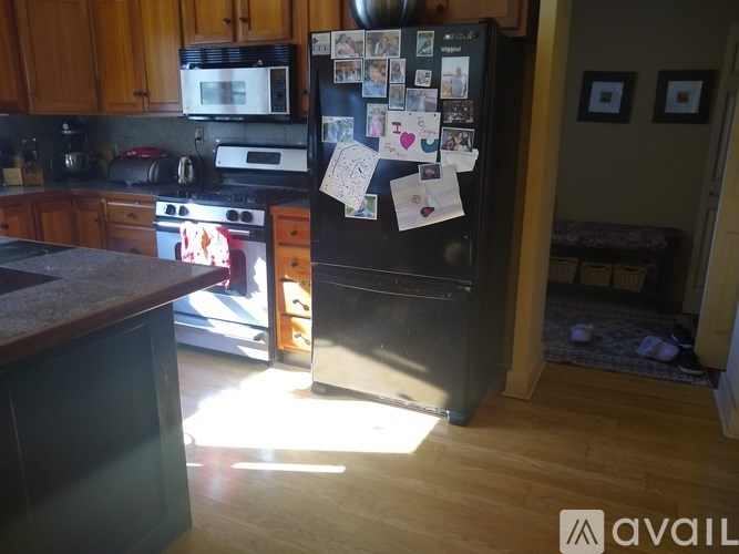 A kitchen with a refrigerator covered in photos and notes.