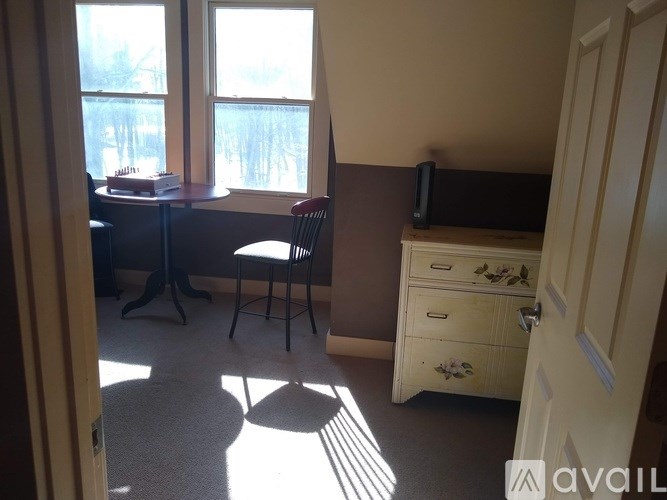 A room with a desk, chair, and a dresser with a mirror.