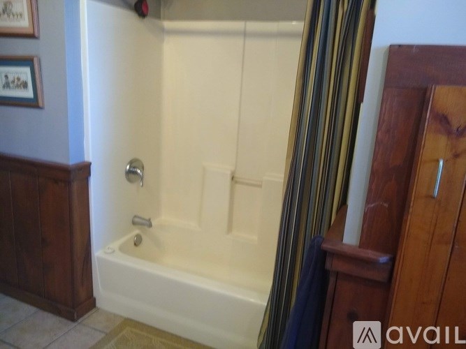A white bathtub with a silver faucet is in a bathroom.