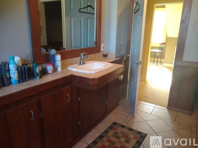 A bathroom with a sink, mirror, and cabinets.