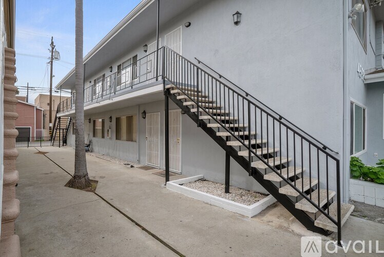 A white building with a black metal staircase outside.