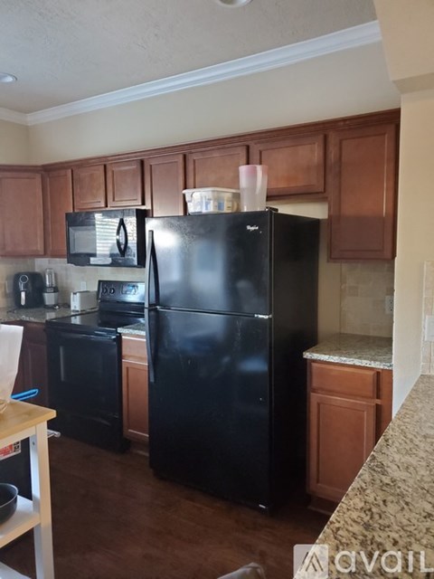 A kitchen with black appliances and wooden cabinets.