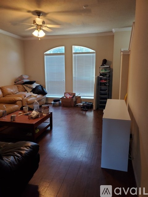 A living room with a brown leather couch and a white cabinet.