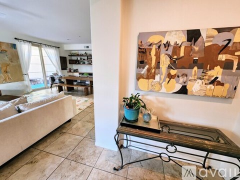 A living room with a large abstract painting on the wall.