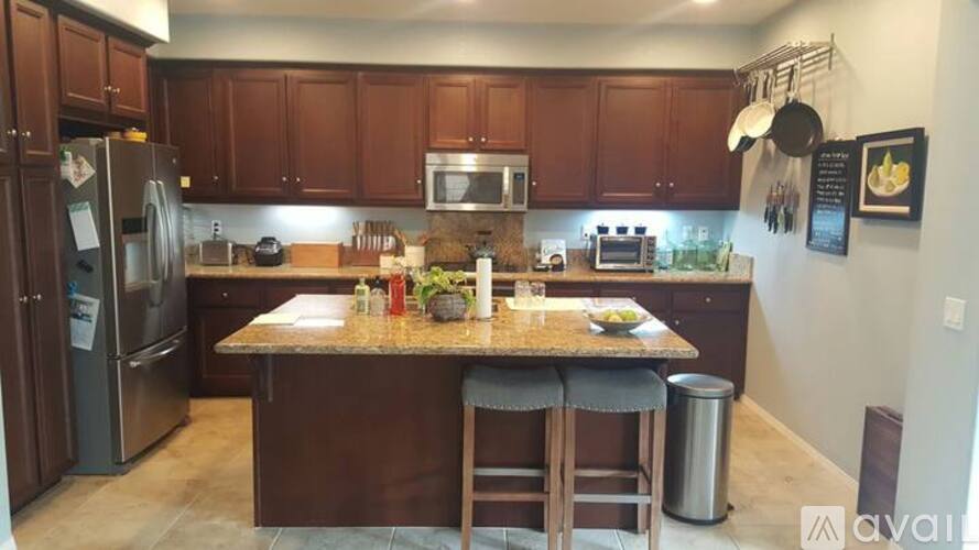 A kitchen with brown cabinets and a granite countertop.