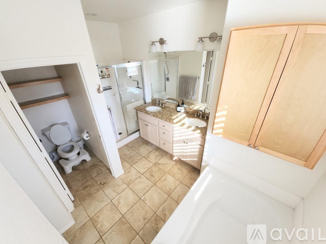A small bathroom with a toilet and shelves above it.