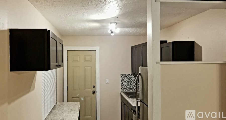 A kitchen area with a microwave, oven, and refrigerator.