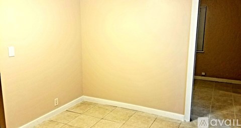 A room with beige walls and tiled flooring.