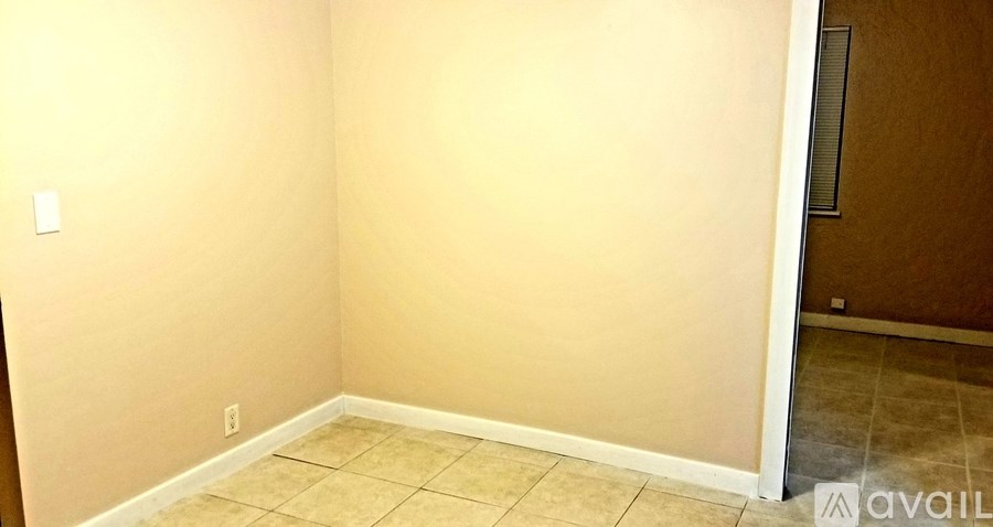 A room with beige walls and tiled flooring.