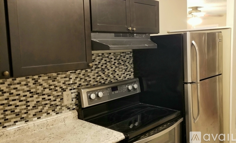 A kitchen with a black oven and a black and white tiled backsplash.