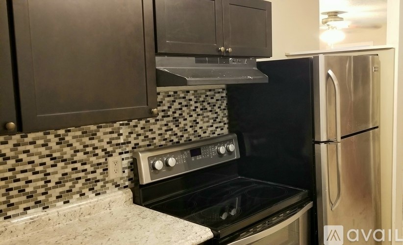 A kitchen with a black oven and a black and white tiled backsplash.