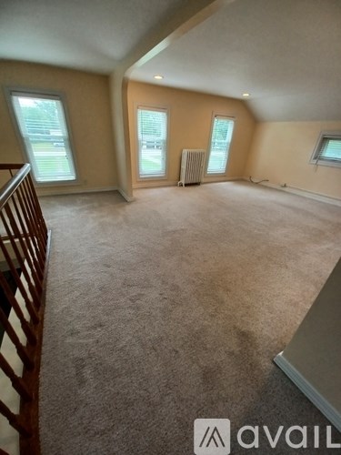 A room with a carpeted floor and a window.
