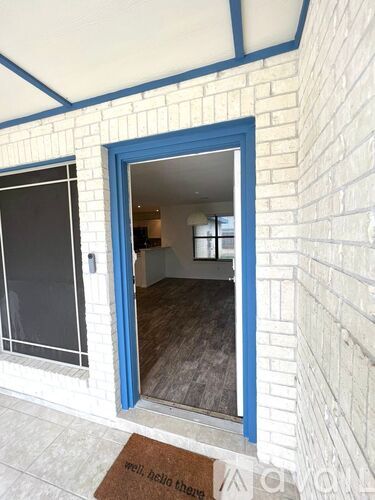 A blue door is open to a room with a brown carpet.