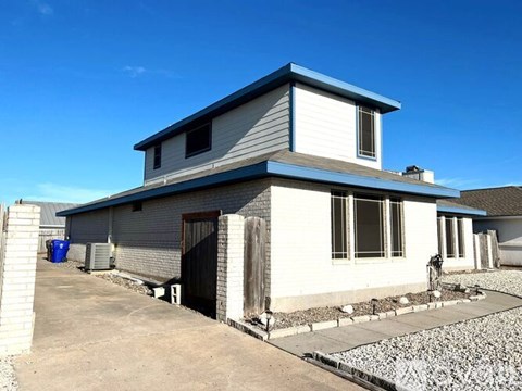 A two-story house with a garage and a driveway.
