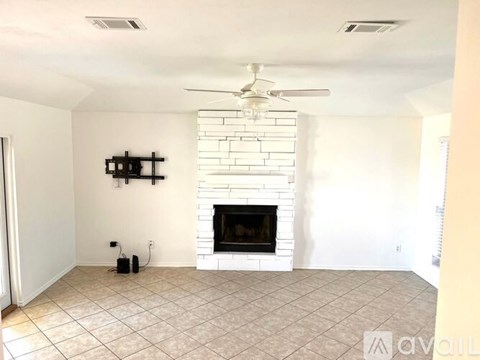 A living room with a fireplace and a fan on the ceiling.