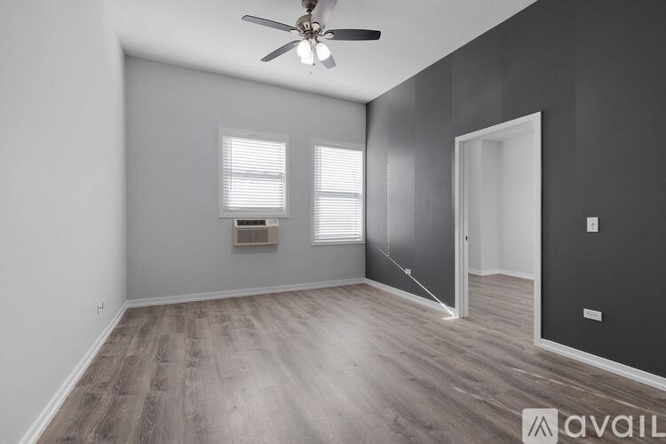A room with a ceiling fan and a window with blinds.