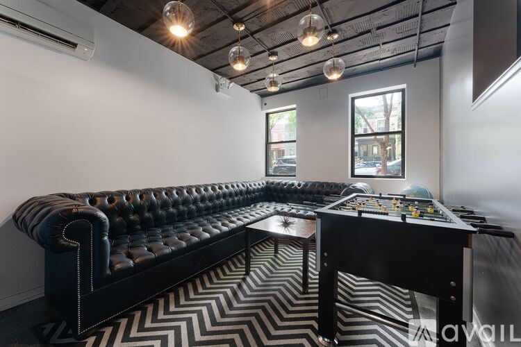 A foosball table is in the middle of a room with a black and white chevron carpet.