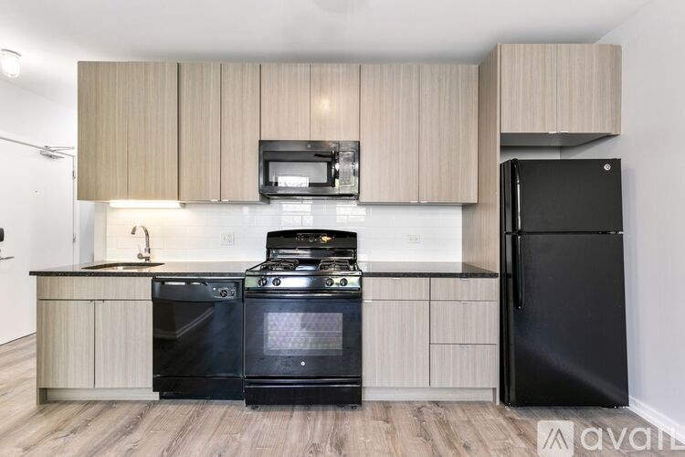 A kitchen with black appliances and wooden cabinets.