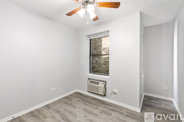 A room with a ceiling fan and a window with blinds.
