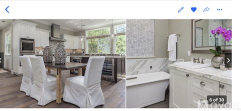 A modern kitchen with white chairs and a marble countertop.