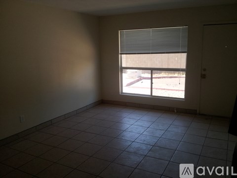 A room with a tiled floor and a window with blinds.