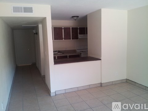 A kitchen area with white walls and a tiled floor.