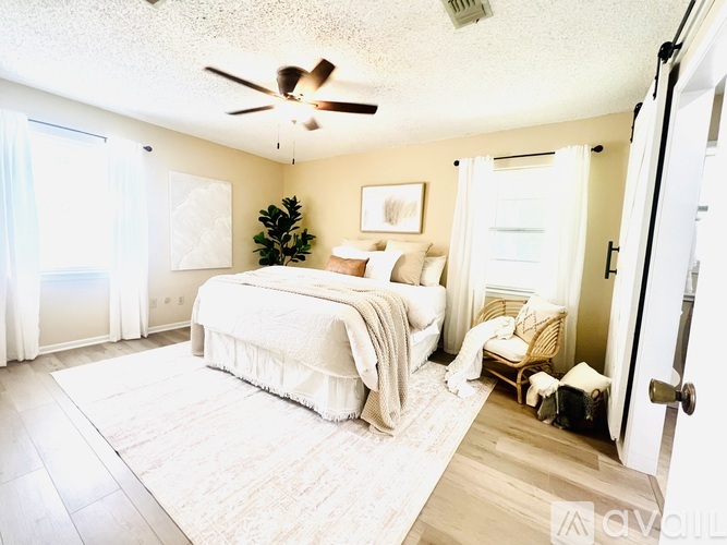 A bedroom with a large bed and a ceiling fan.