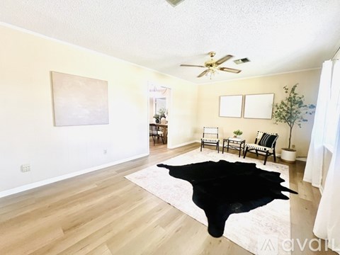 A living room with a black cowhide rug on the floor.