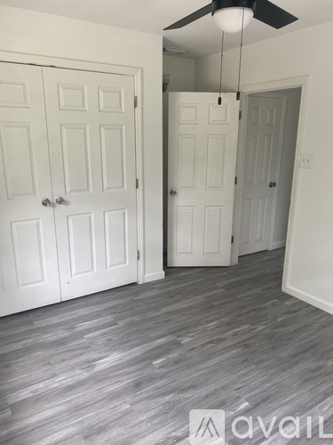 A room with a ceiling fan and two doors.