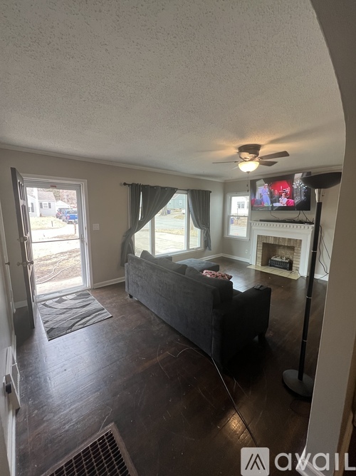 A living room with a couch, television, and fireplace.